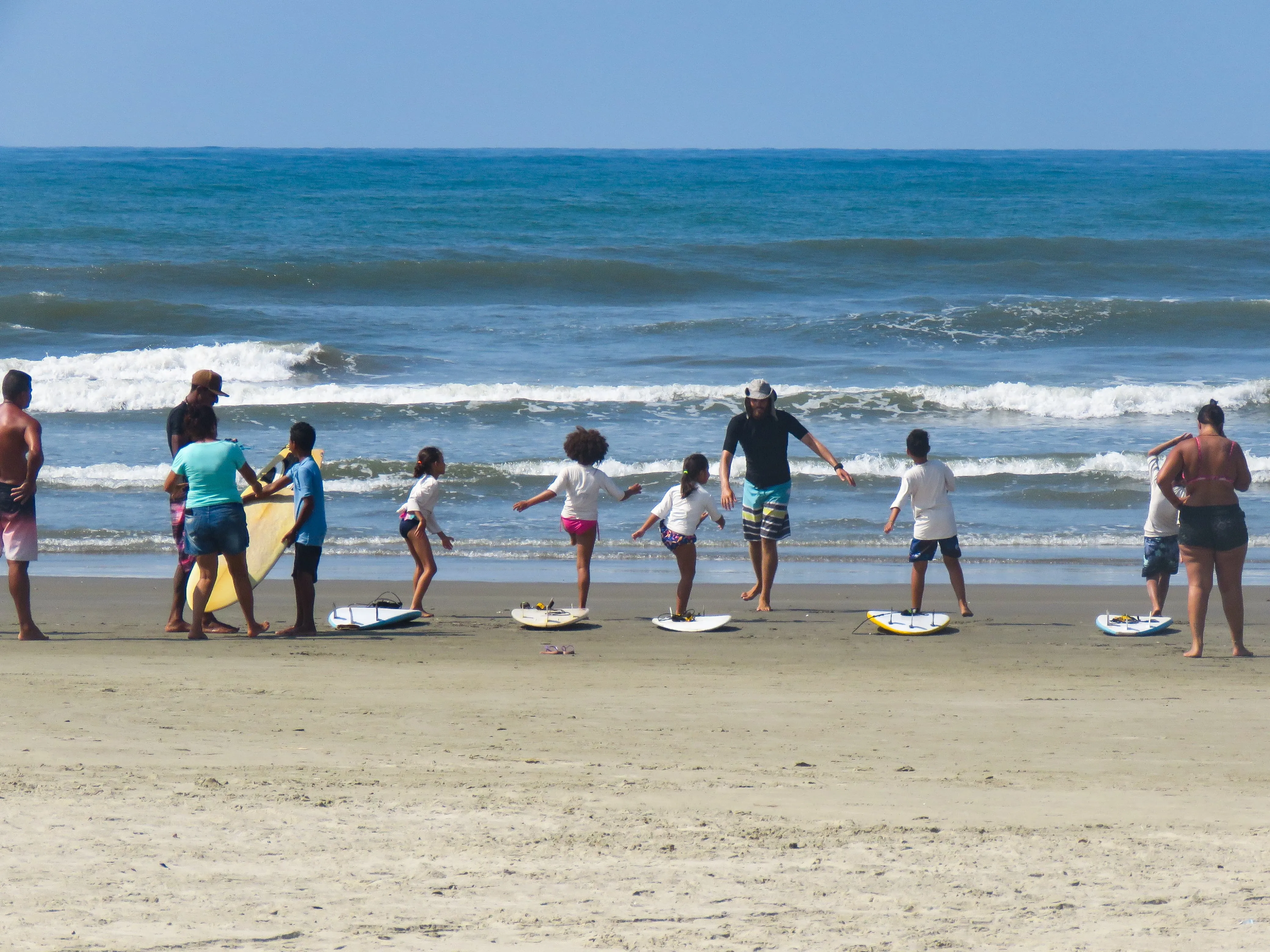 Crianças com prancha de surf na praia após treino