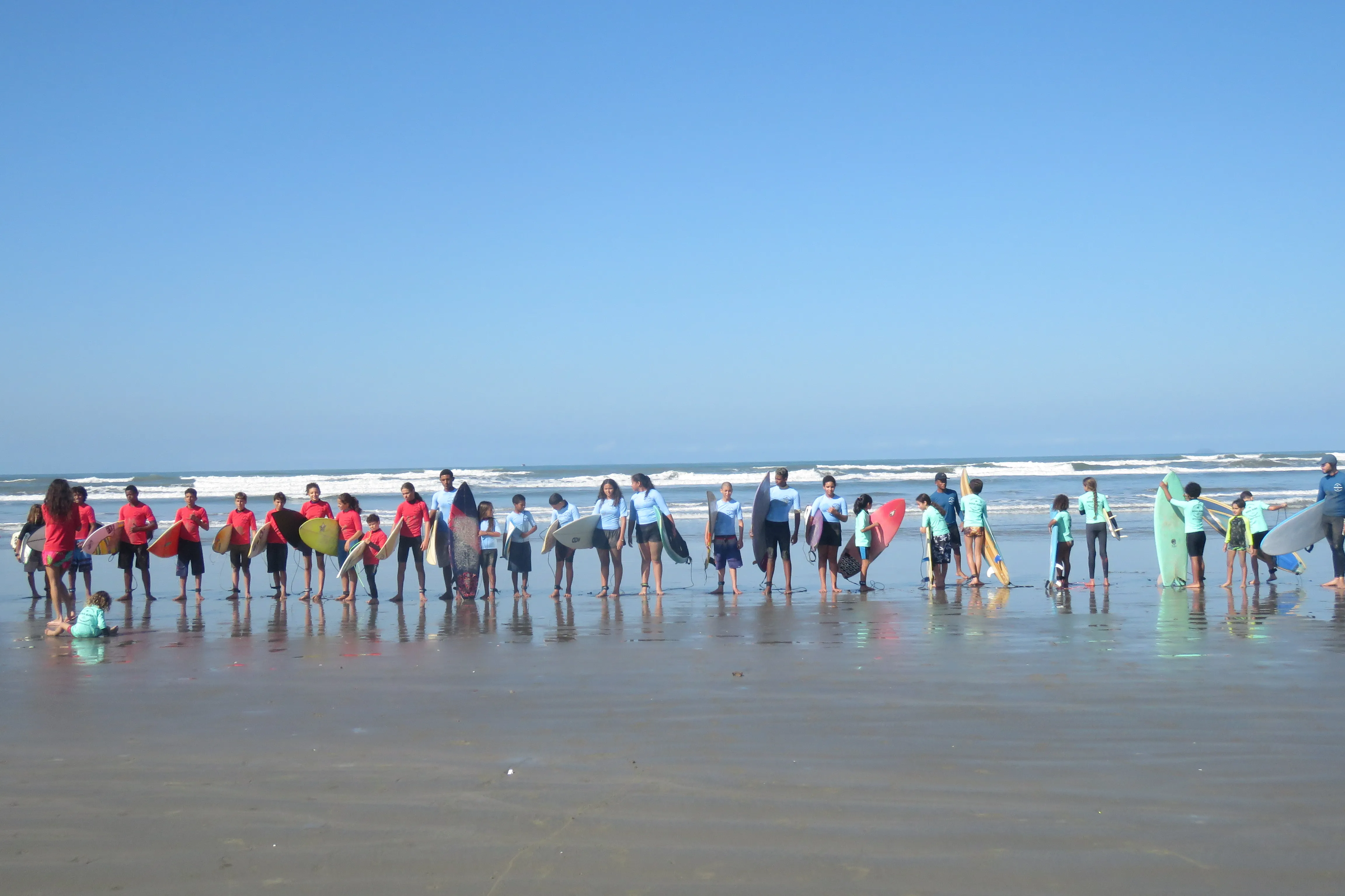 Crianças aprendendo técnicas de surf na areia