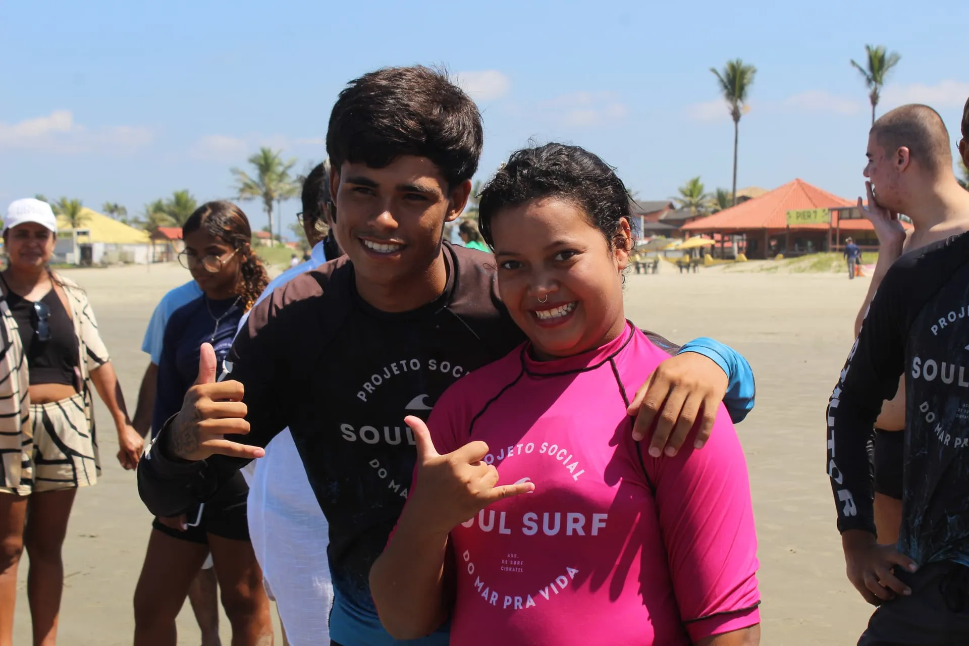Crianças aprendendo técnicas de surf na areia